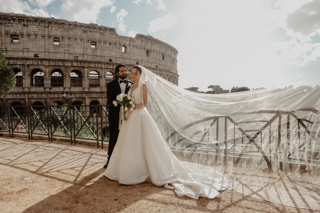A wedding couple is posing in front of Colosseum