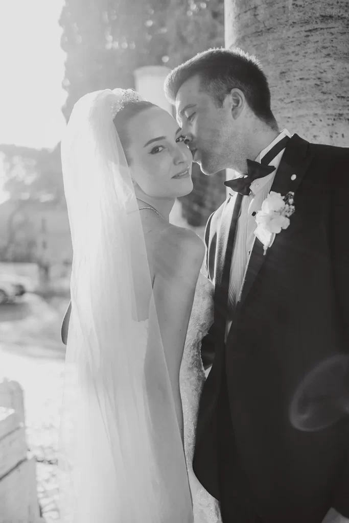 a groom is kissing his wife