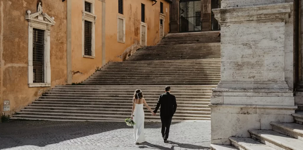 bride and groom holding hands and walking towards the stairs