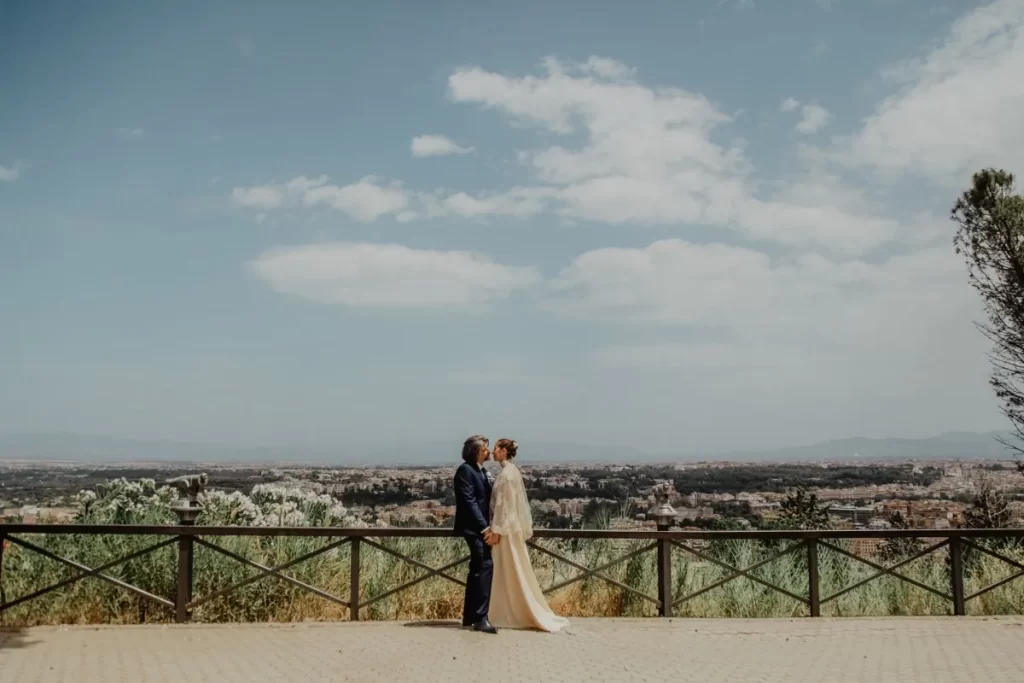 wedding couple is kissing with Rome landscape in the background