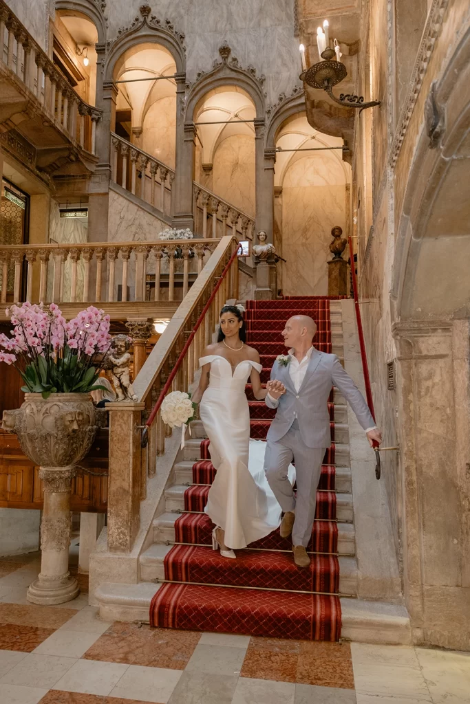 a wedding couple is climbing down the stairs in the Hotel Danieli in Venice
