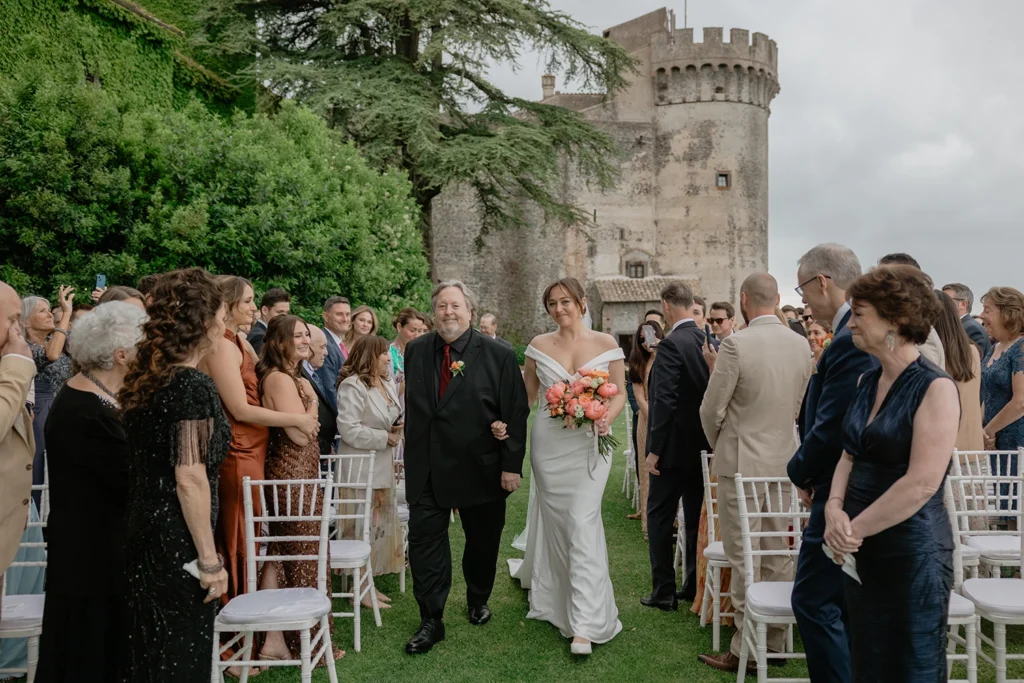 A bride is walking the isle with his dad at Castello Orsini Odescalchi di Bracciano
