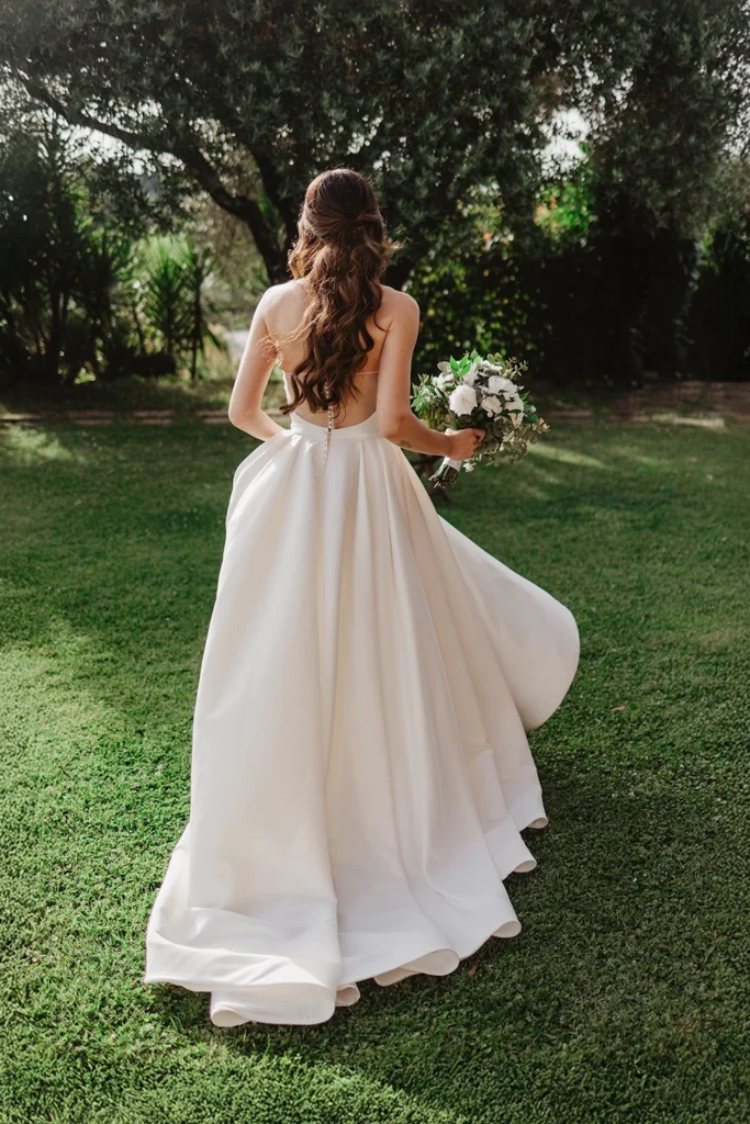 a bride is walking in a garden