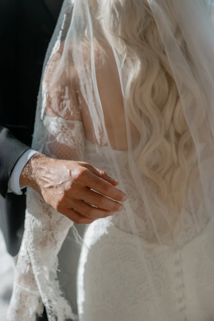 detail of a man's hand on a bride's back