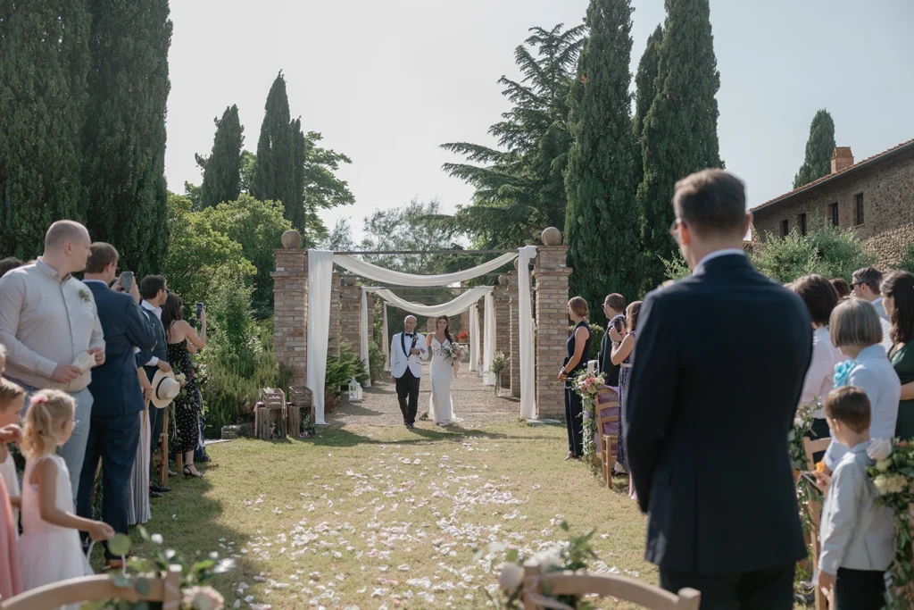 a bride is walking towards the wedding ceremony at Agriturismo la Mandriola, Lajatico Tuscany