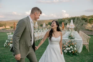 a newlywed couple is smiling between tables at Le Filigare, Tuscany
