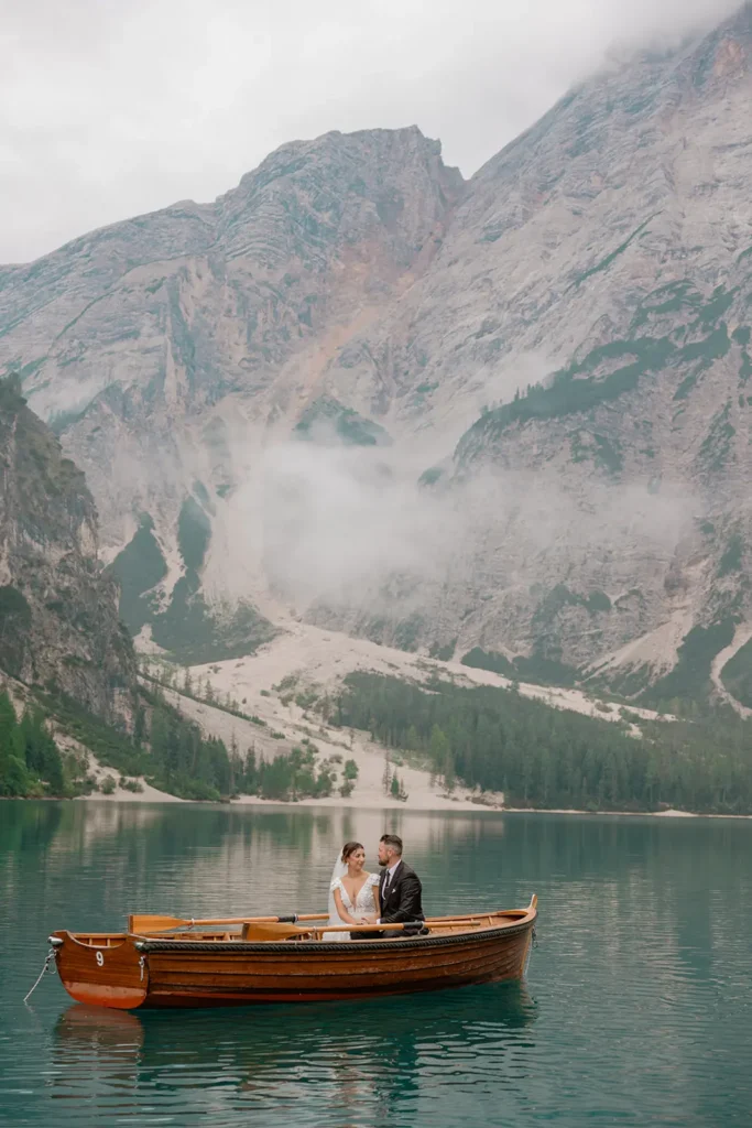 a wedding couple is in a woodboat in Lake Braies Dolomites by Cristiana Fiorini
