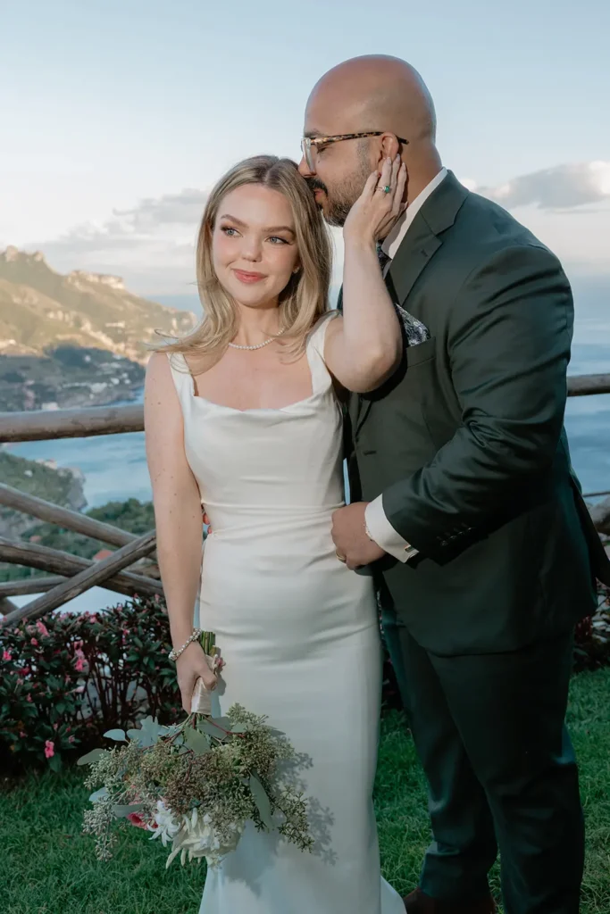 a couple is standing with sea views in their backdrop. Ravello