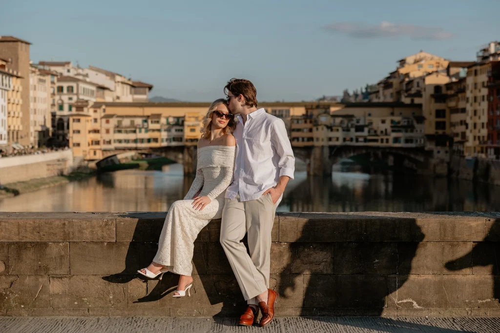 a couple is sitting in Ponte Vecchio Florence